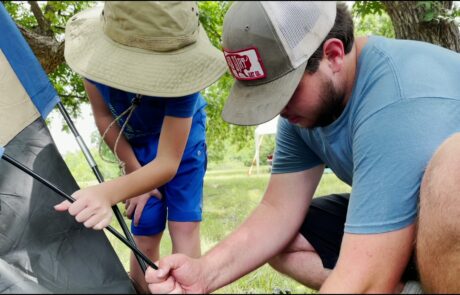 Matt helps boy put up tent